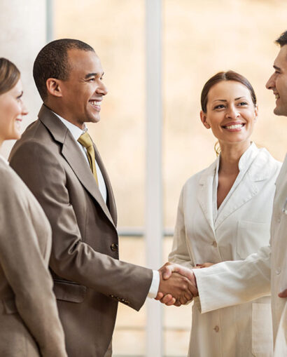 Business people collaborating with doctors. African American businessman shaking hands with a male doctor.