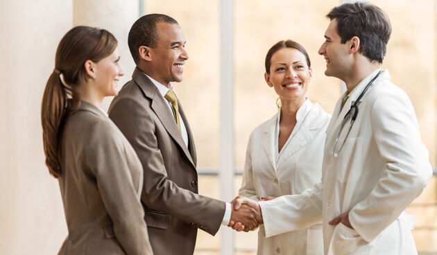 Businessman shaking hands with a doctor. Business people collaborating with doctors. African American businessman shaking hands with a male doctor.