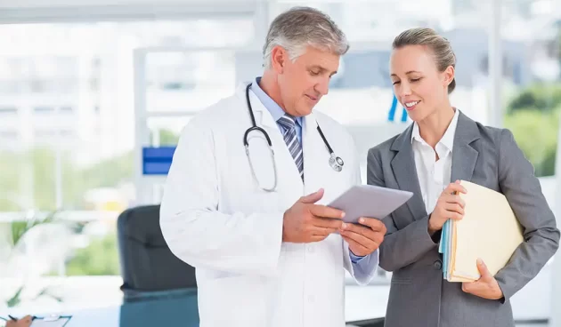 Confident doctor and pretty businesswoman discussing Confident doctor and pretty businesswoman discussing in medical office