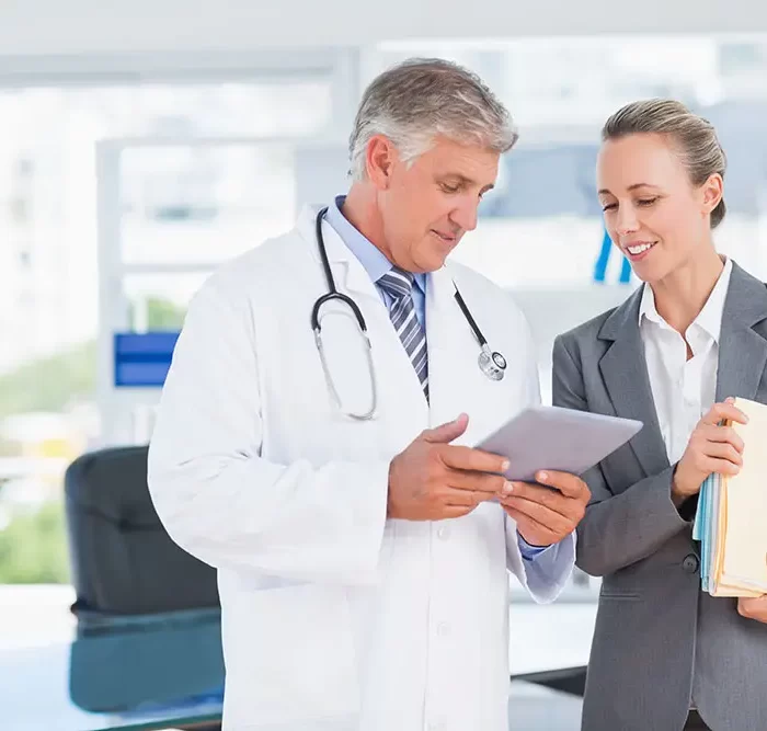 Confident doctor and pretty businesswoman discussing in medical office