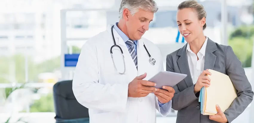 Confident doctor and pretty businesswoman discussing in medical office